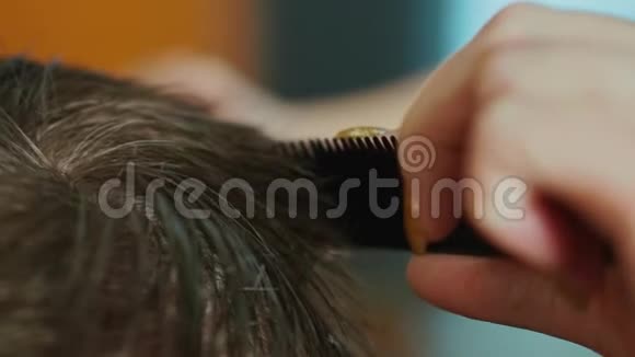 理发师在美发沙龙剪男孩头发的手的特写镜头选择性聚焦视频的预览图