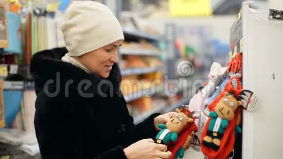 一个穿黑色外套的女人为圣诞树选择圣诞装饰品圣诞节购物视频的预览图