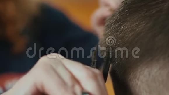 在美发沙龙剪小男孩头发的理发师的双手合拢有选择的焦点头发视频的预览图
