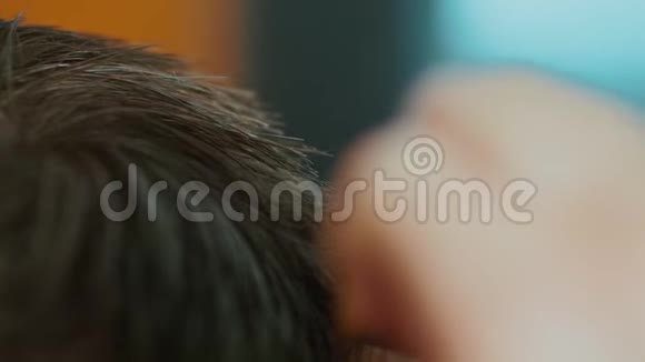 理发师在美发沙龙剪男孩头发的手的特写镜头选择性聚焦视频的预览图