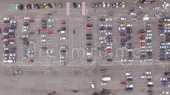空中摄像机飞过大超市附近繁忙肮脏的停车场视频的预览图