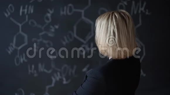 一个女人用公式站在董事会附近解决一项困难任务的肖像科学的概念布局视频的预览图
