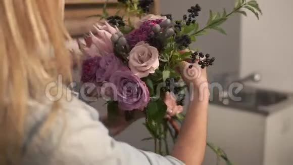 侧视女性金发花店布置现代花束看花是如何组合的可爱的花朵视频的预览图