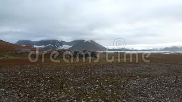 北冰洋沙漠海岸的老房子以山脉为背景视频的预览图