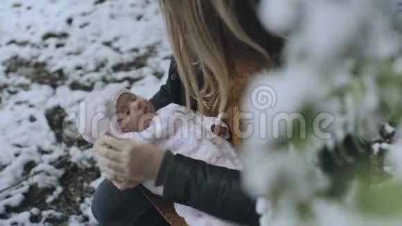 年轻女子在冬天的森林里抱着她的小女孩视频的预览图