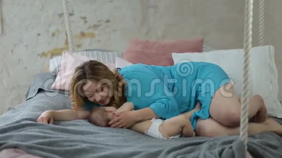 美丽的妈妈吻着熟睡的小女孩视频的预览图
