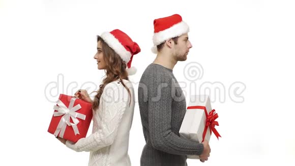 年轻夫妇穿着毛衣转身带着礼物互相惊喜视频的预览图