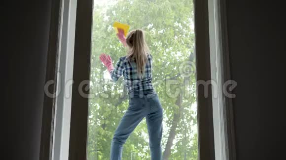 人们家务和家务的观念幸福的女人戴着手套用抹布擦窗户在家里喷清洁剂视频的预览图
