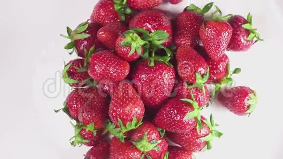 白色盘子上的湿草莓慢动作视频的预览图