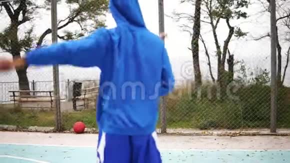 两个年轻的朋友在街上打篮球前热身慢镜头视频的预览图
