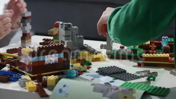 孩子们手拿着一块乐高积木玩双手合拢乐高是一种流行的建筑玩具视频的预览图