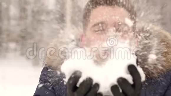 一个年轻人在雪地上吹风的特写镜头视频的预览图