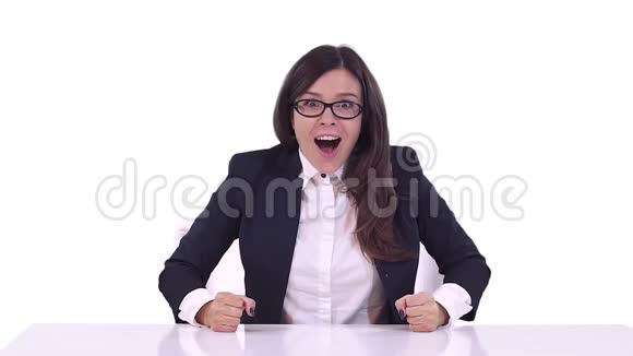女商人西装革履她坐在办公桌后面享受着一笔好交易微笑着挥舞着手臂视频的预览图