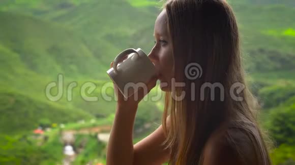 年轻女子坐在咖啡馆里观看高地茶种植和喝茶视频的预览图