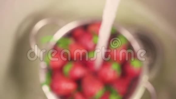 一股水流缓慢地涌进一个草莓的大视频的预览图
