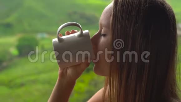 年轻女子坐在咖啡馆里观看高地茶种植和喝茶视频的预览图