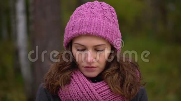 头疼的女人闭上嘴秋天公园里坐在长凳上头痛的不开心的漂亮女人慢慢慢慢视频的预览图
