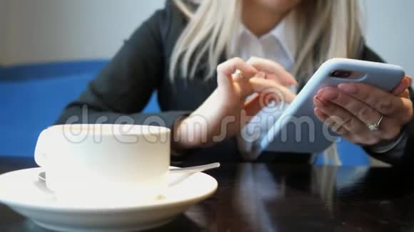 在咖啡馆里拿着电话的面目全非的女孩视频的预览图