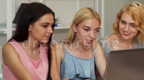 快乐的美女们一起笑着用笔记本电脑视频的预览图