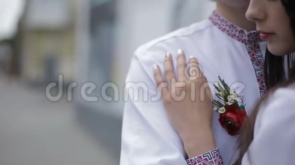 夫妇在乌克兰刺绣布温柔地拥抱户外布托尼埃装饰这个人的近景视频的预览图