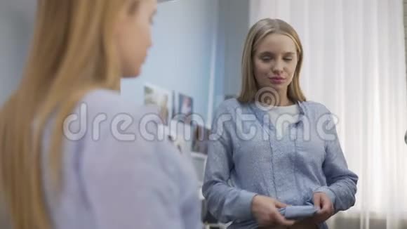 金发女孩站在家里的镜子旁边摆姿势个人风格吸引力视频的预览图