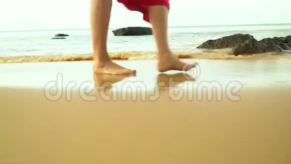 那个女人在海洋的背景下沿着海岸走普夸克岛沙子上的腿痕视频的预览图