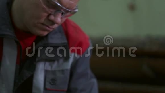 一个戴安全眼镜的人的特写镜头在锯木厂工作视频的预览图
