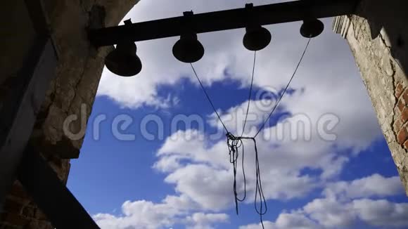 蓝天背景上的钟声伴随着云彩各种大小的钟声悬挂在高海拔的砖拱上视频的预览图