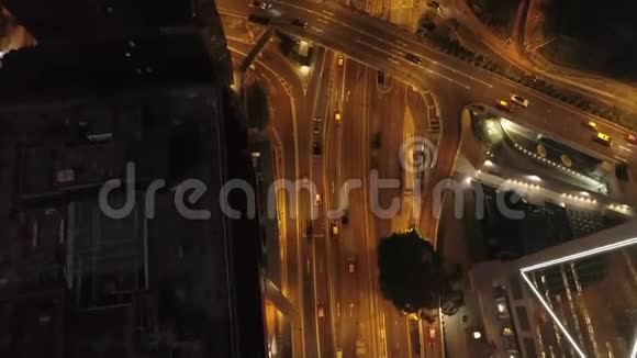 鸟瞰现代道路交叉口建筑物和夜间行驶的汽车股票夜间交通道路视频的预览图