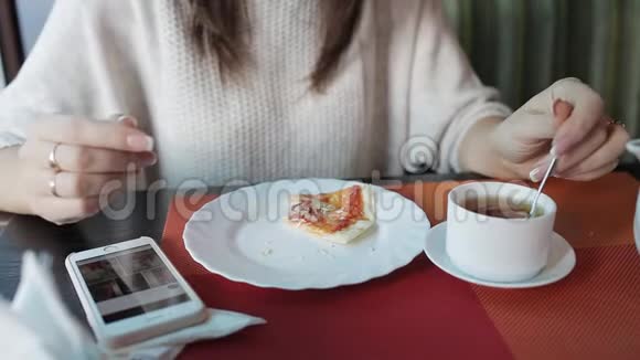 一个女人在咖啡馆里吃披萨用手机社交和电子邮件晚餐和网页浏览视频的预览图