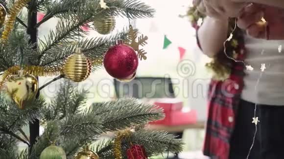 快乐的亚洲女人拿着圣诞装饰品在她的办公室装饰圣诞树漂亮的女人和她的朋友一起度假视频的预览图