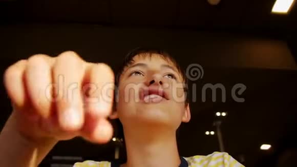 青少年吃快餐在快餐店里青少年男孩咬薯条的特写镜头视频的预览图