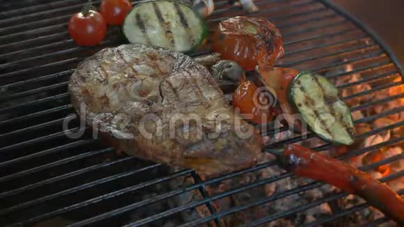 蔬菜和鱼烤架牛排鱼厨师在夏季露台上用铁钳翻过来视频的预览图