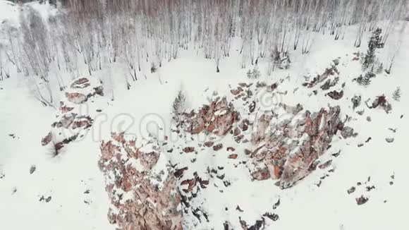 空中射击多雪的岩石山日落或日出晴空万里阳光明媚冬林中落石山视频的预览图