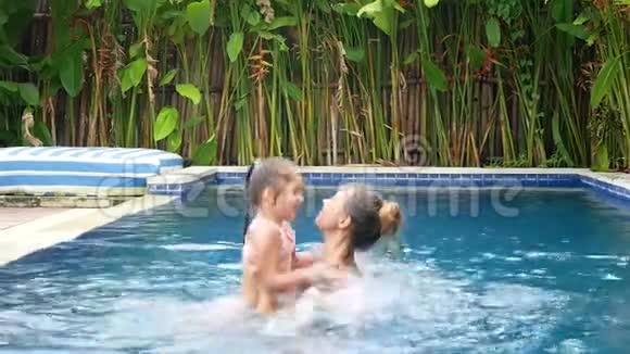 快乐的妈妈和女儿在游泳池里玩得很开心视频的预览图