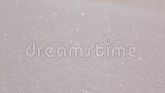 糖或盐倒在黑色背景上一堆溢出的白砂糖视频的预览图