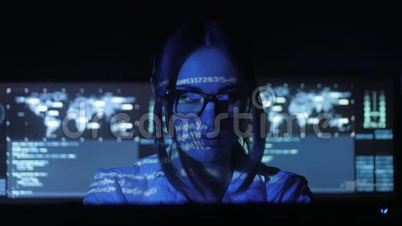 戴眼镜的女黑客程序员正在电脑安全中心工作里面放满了显示屏二元视频的预览图