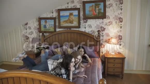 三个年轻的女孩在时髦的家里床上放松慢慢地视频的预览图