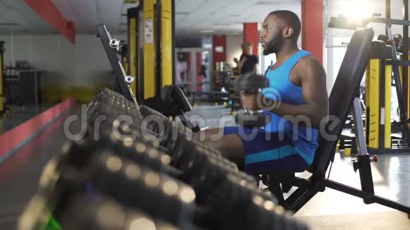 男运动员在健身房用哑铃锻炼积极健康的生活方式健身视频的预览图