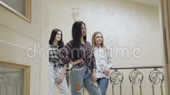 三个漂亮的女孩站在家里的楼梯上摆姿势慢慢地视频的预览图
