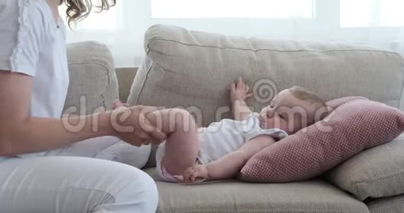 妈妈和躺在沙发上的女婴玩视频的预览图