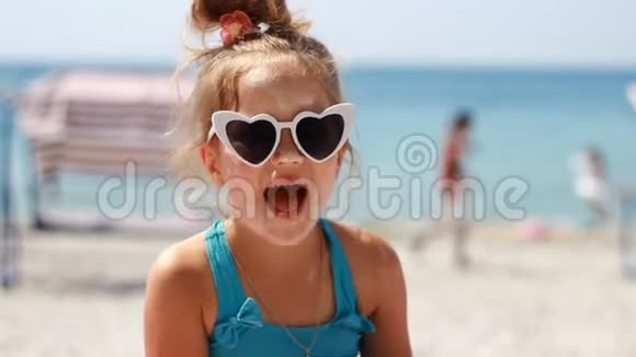 快乐的孩子靠近大海晒伤防晒霜防晒霜可爱的小女孩戴着太阳镜在一个视频的预览图