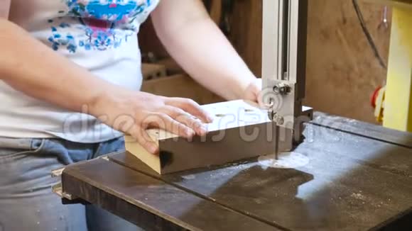 工匠正在用锯条从木头上切割一个木制玩具汽车的工件双手特写视频的预览图