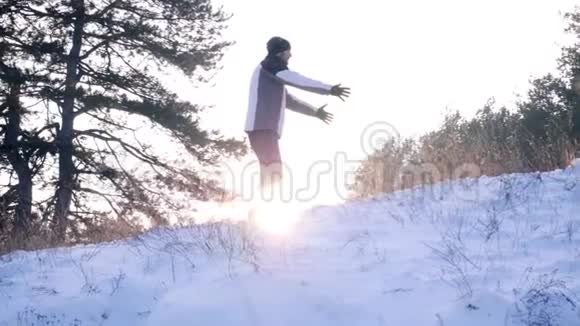 小男孩碰到爸爸的手他们在森林里的背光下缓慢地落在雪地上视频的预览图