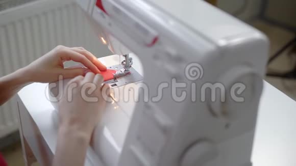 一位女士的手紧紧她在一台电动缝纫机后面工作她在一块布上缝了一针视频的预览图