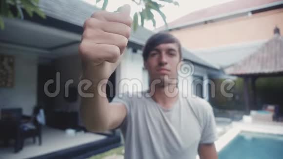 快乐的年轻人伸出大拇指在院子里的室外微笑视频的预览图