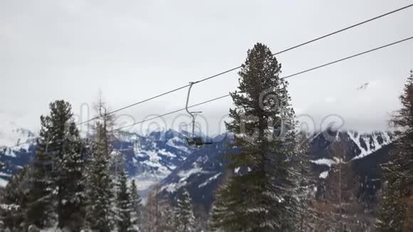 滑雪电梯在雪山的背景下空椅子在美丽的山冬的背景下移动视频的预览图
