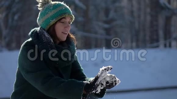慢镜头漂亮的女孩在镜头前扔雪球视频的预览图