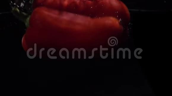 红铃椒落水慢动作黑色背景食物录像视频的预览图