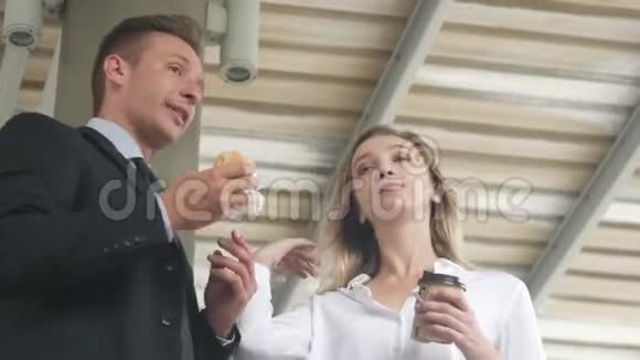 早晨商务人士和朋友带着咖啡杯和汉堡包在空中散步视频的预览图